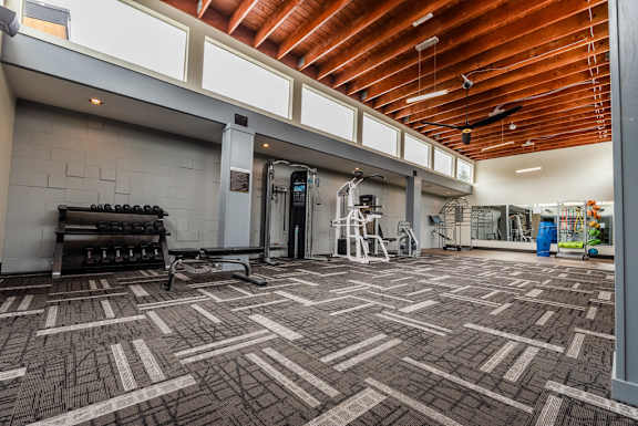 the lobby of a gym with a tile floor and wood ceilings
