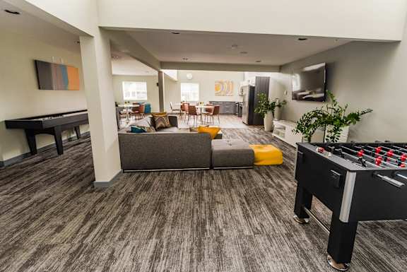 a living room with a foosball table and a game controller