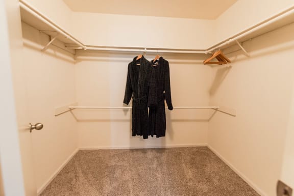 a walk in closet with two dresses hanging on a hangar