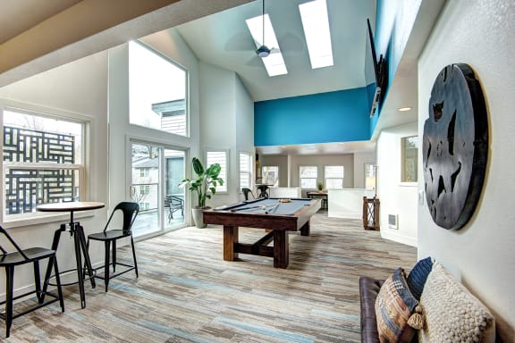 a game room with a pool table and a large window at The Lynx Apartments, Everett, Washington