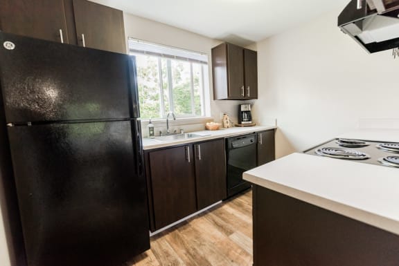 a kitchen with black appliances and a window at Vibe, Kent, WA