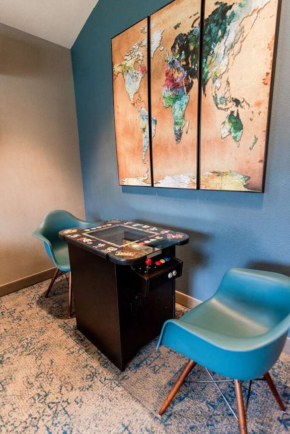 A room with a blue chair, a blue chair, and a world map on the wall. at Vibe, Kent, 98030