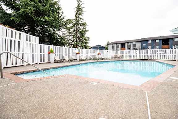 A small pool surrounded by a white fence. at Vibe, Washington, 98030