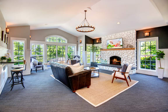 a large living room with a stone fireplace and a couch at Deer Creek Apartments, Washington
