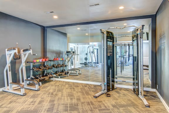 a fitness room with cardio machines and mirrors at Deer Creek Apartments, Puyallup, Washington