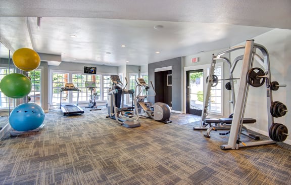spacious gym with cardio machines and weights at the at the village apartments at Deer Creek Apartments, Puyallup, WA, 98373