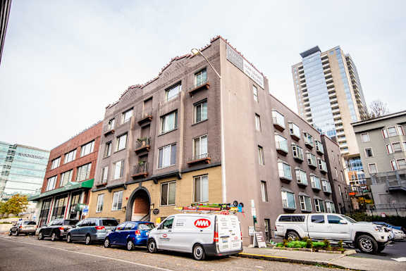 an old building on a city street with parked cars at Zindorf, Seattle, 98104