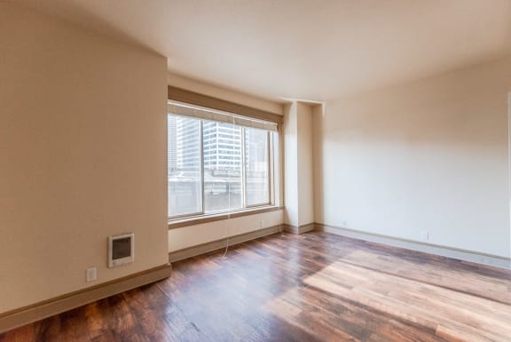 an empty living room with hard wood floors and a large window at Zindorf, Seattle, Washington
