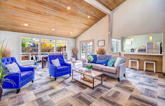 A living room with a blue chair and a grey couch. at The Lakes at Fife, Fife, WA