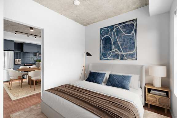A bedroom with a large bed and a painting on the wall.