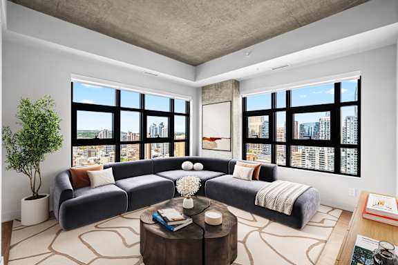 A living room with a large sectional sofa and a coffee table in front of a large window.