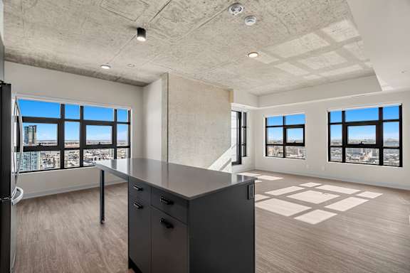 A large, empty room with a desk and a view of the city.