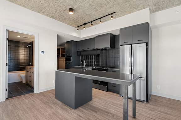 A modern kitchen with a stainless steel refrigerator and a central island.