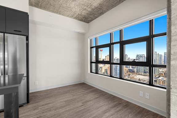A spacious empty room with a large window overlooking a cityscape.
