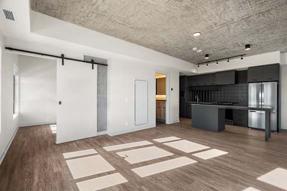 A kitchen area with a white wall and a black counter.