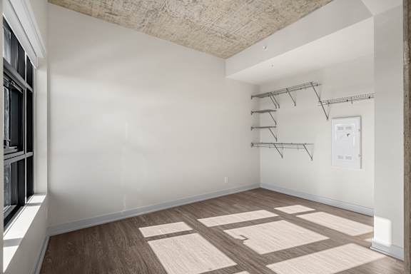 A room with a concrete ceiling and wooden flooring.