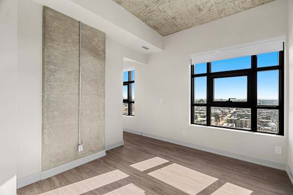 A room with a large window and a concrete wall.