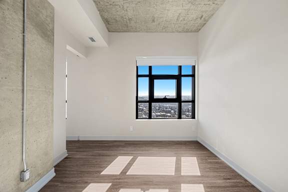 A room with a large window and a concrete ceiling.
