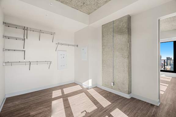 A room with a white wall and a brown floor.