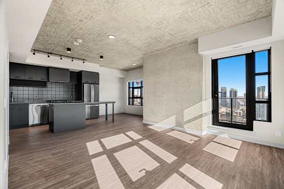 A kitchen with a large island and a view of the city.