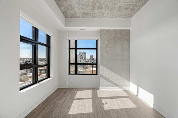 A room with a large window and a view of a city skyline.