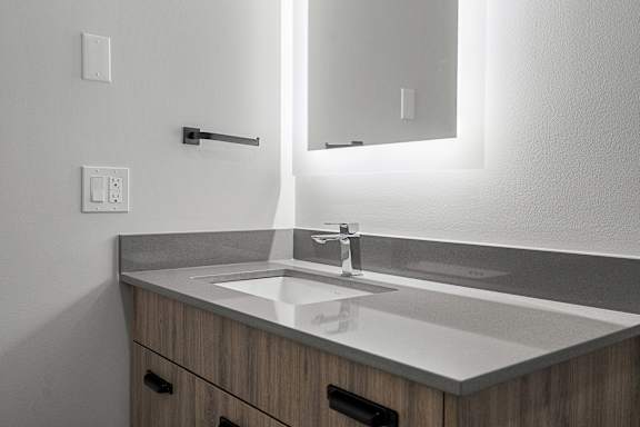 A modern bathroom with a sink and mirror.