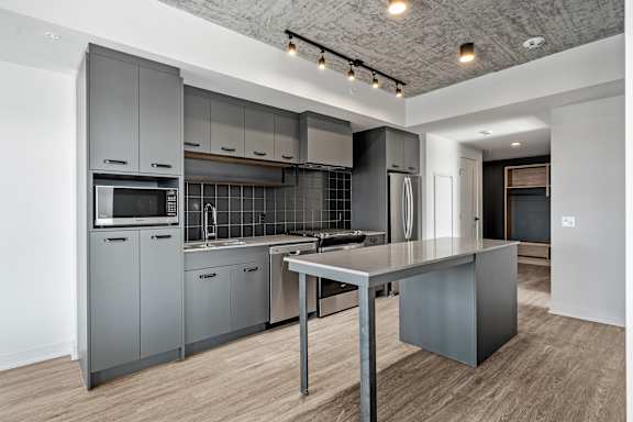 A modern kitchen with a large island and stainless steel appliances.