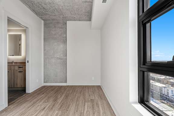 A room with a large window and a wooden floor.