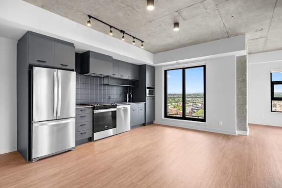 A modern kitchen with stainless steel appliances and wooden floors.