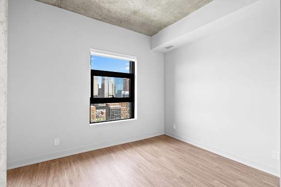 A room with a window showing a cityscape outside.