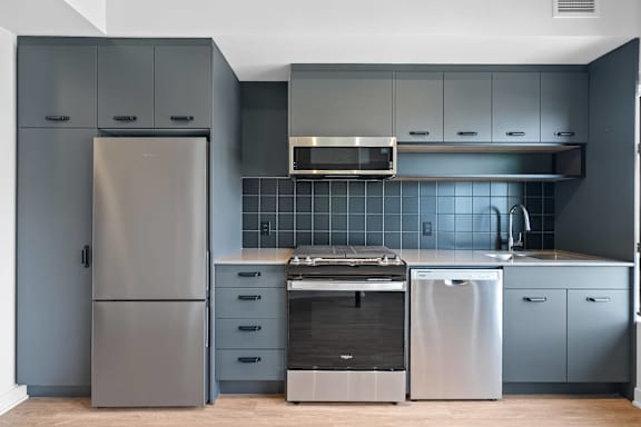 A modern kitchen with a stainless steel refrigerator and a dishwasher.