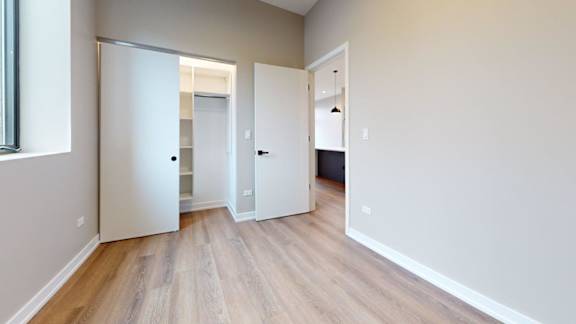 A room with a sliding door and wooden flooring.