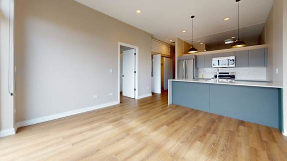 A kitchen with a blue counter and wooden floors.