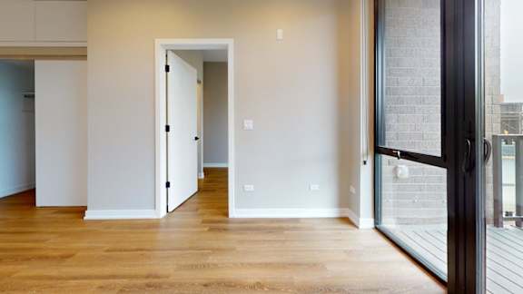 A room with a wooden floor and a white door.