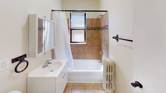 A bathroom with a white sink and a bathtub with a shower curtain.