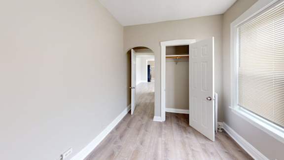 A room with a white door and a window with blinds.