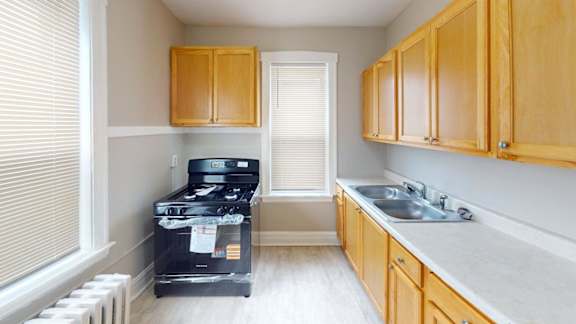 A kitchen with wooden cabinets and a black stove top oven.
