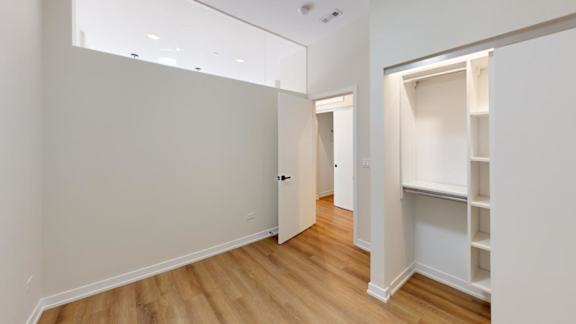 a bedroom with a closet and a hard wood floor