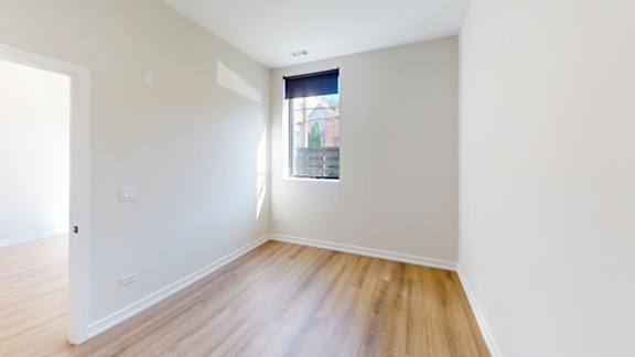 a room with white walls and a window and wooden floors