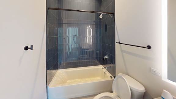 a bathroom with a tub and a toilet and a shower