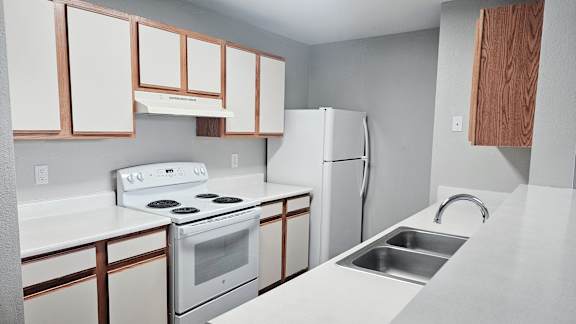 A white stove and oven in a kitchen with white cabinets.