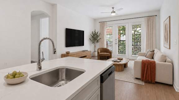 A modern kitchen with a bowl of pears on the counter.