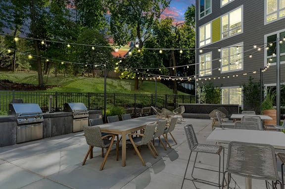 A patio with tables and chairs and string lights.