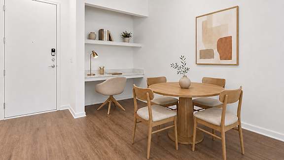 A dining room with a round table and chairs.