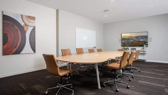 A conference room with a large table and chairs.