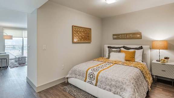 A bedroom with a large bed and a lamp on the side table.