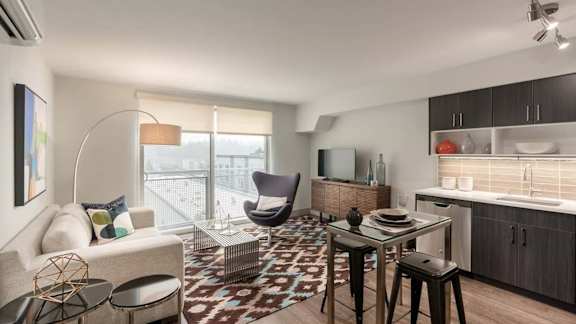 A modern living room with a sofa, chairs, and a dining table.