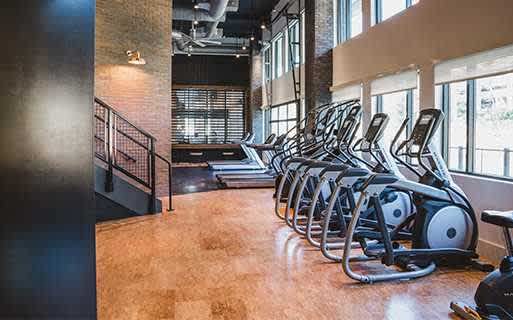A gym with a row of stationary bikes.