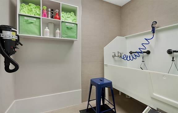 A bathroom with a white tub and a blue stool.