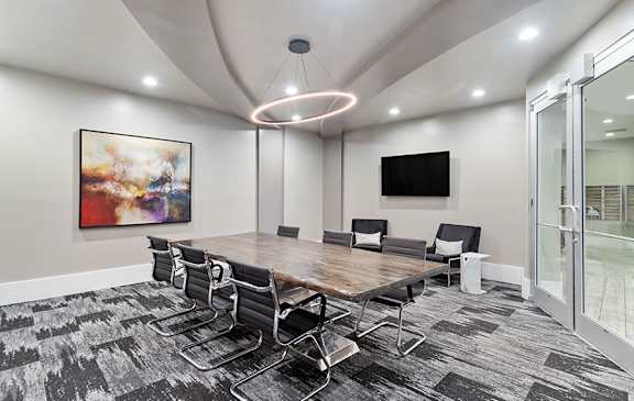 A conference room with a long table and chairs.